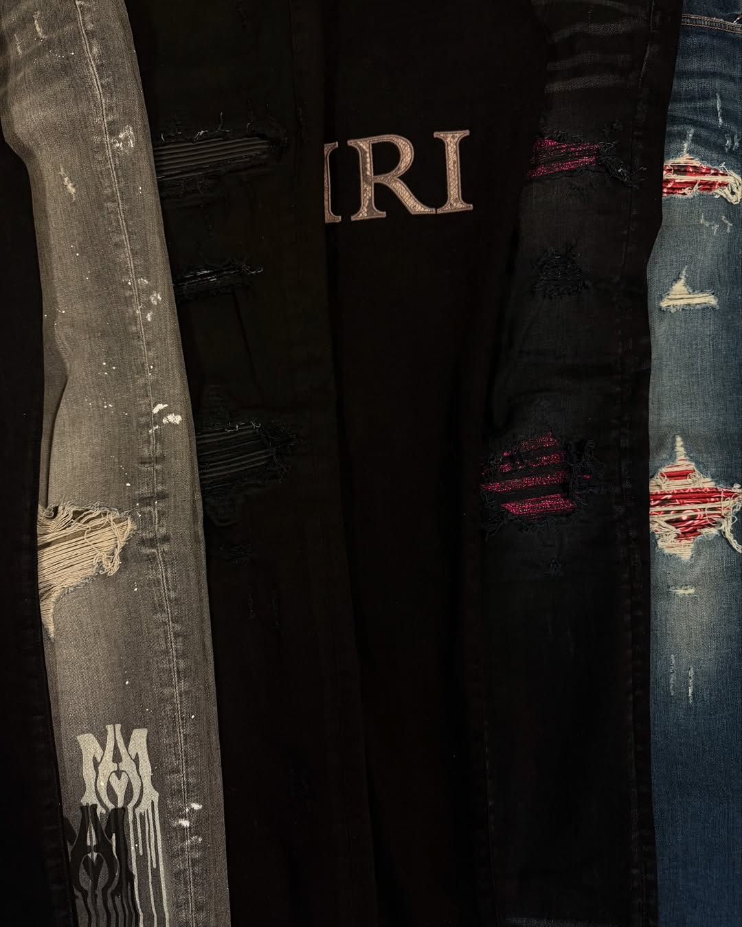 Five pairs of distressed denim displayed together